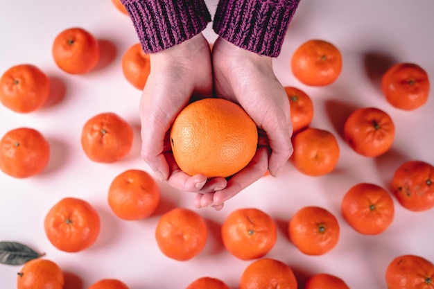 Orange in woman hands delicious mandarins on white background