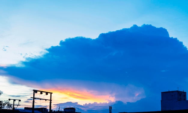 Orange yellow pink purple blue colors play on the cloudy city sky at sunset