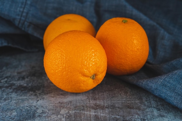 Oranges fruit near denim textile on dark board Orange juicy fruit citrus minimal concept