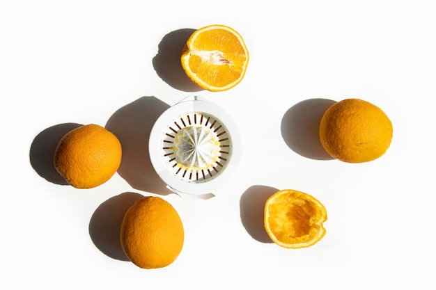 Oranges and hand bowl for making fresh juice on a white background Top view flat lay