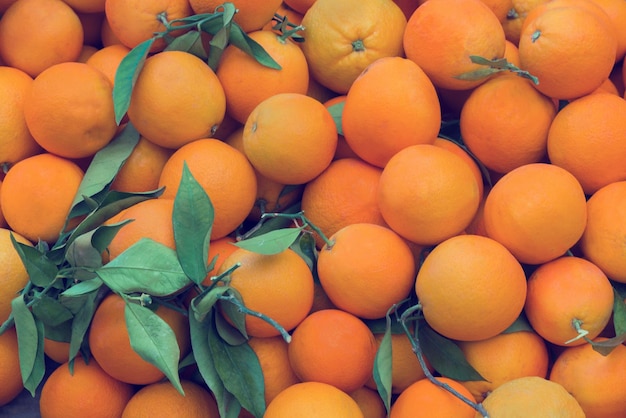 Oranges with leaves background Toned