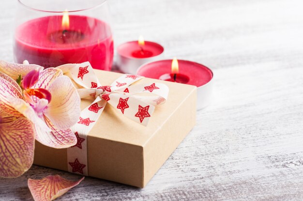 Orchids, craft gift box and lit candles