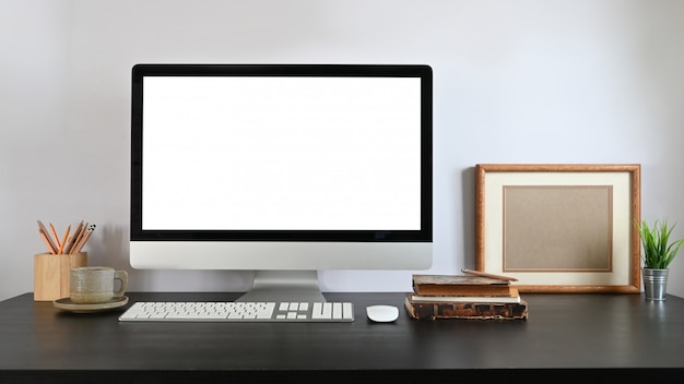 An orderly workplace is surrounding by computer monitors and office equipment.