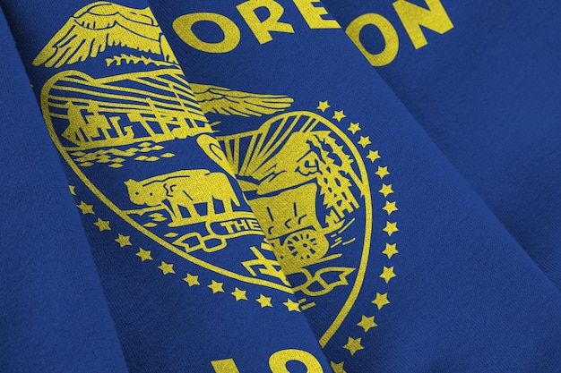 Oregon US state flag with big folds waving close up under the studio light indoors The official symbols and colors in banner