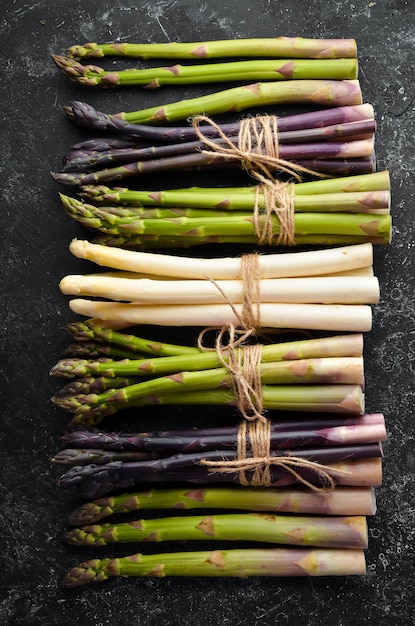 Organic asparagus on a black background Set of colored asparagus Top view Free space for your text