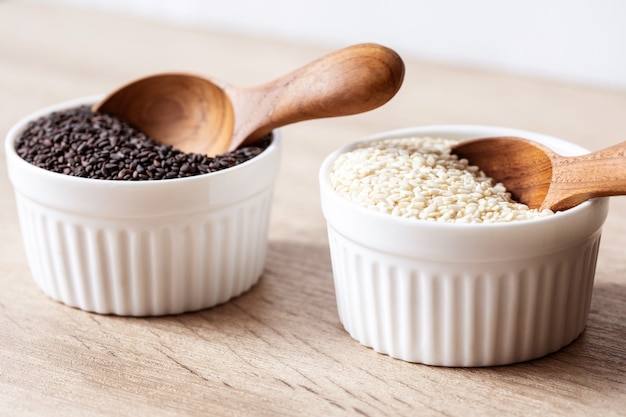 Organic Black and a white sesame seeds in wooden spoon 