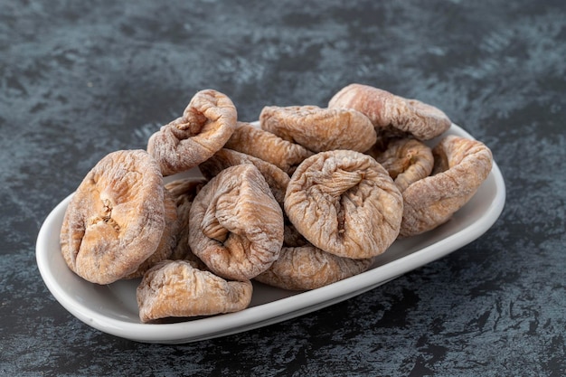 Organic dried figs on plate on dark background