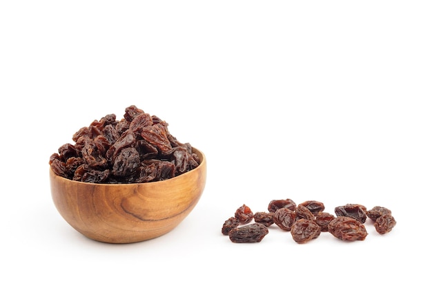 Organic dried Raisins in wooden bowls on white background Currant