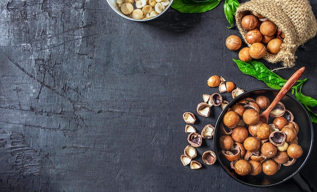 Organic dry Macadamia nut in a brown sack on black wooden background