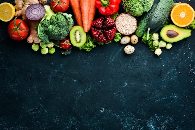 Organic food on a black stone background Vegetables and fruits Top view Free copy space