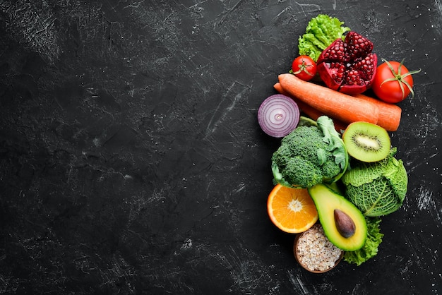 Organic food on a black stone background Vegetables and fruits Top view Free copy space