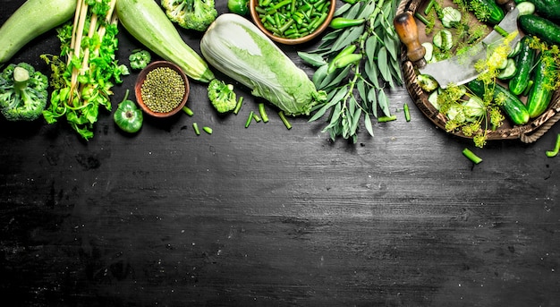 Organic food. Fresh cucumbers with herbs on the black chalkboard.