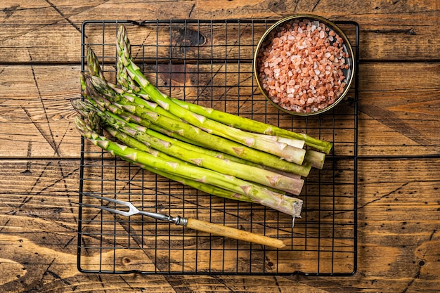 Organic green asparagus ready for cooking Wooden background Top view