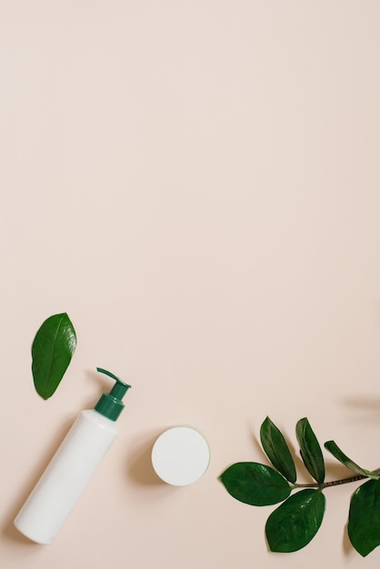 Organic herbal cosmetics in bottles and cans on a beige background with tropical leaves