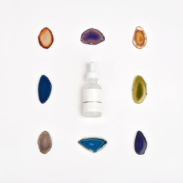 Organic pharmacy cosmetics with natural agate stone on white background. Flat lay. Top view of bottle of cream. Natural beauty products for branding mock-up concept. Composition of natural stones.