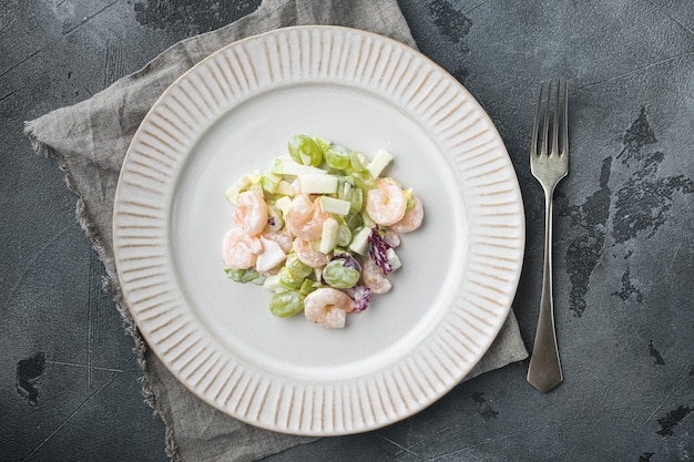 Organic picnic salad of fresh fruits and nuts: celery, fresh seafood set , with sauce apple and grape, on gray table, top view flat lay