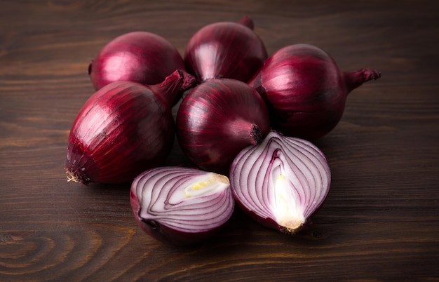 Organic red onions on a wooden background, fresh raw vegetables.