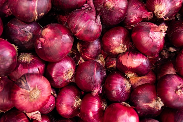 Organic red purple onion in one pile at market. onion background