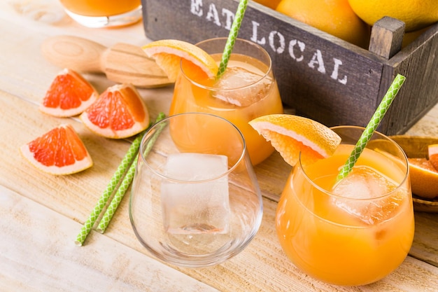 Organic ruby red grapefruit juice in small glass with ice.