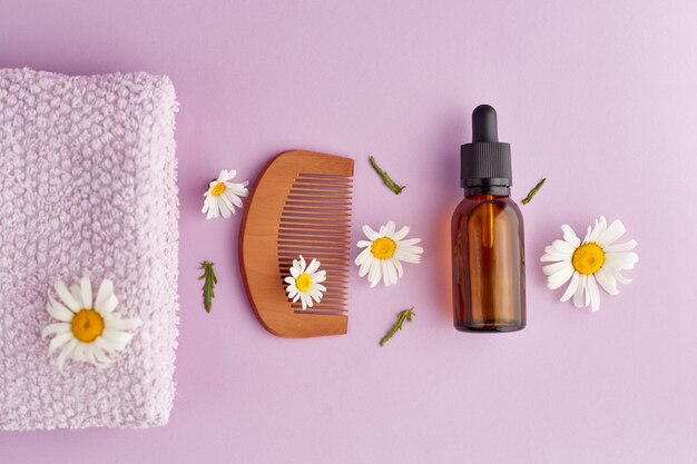 Organic vegan natural cosmetics for hair Flat Lay composition of Chamomile flowers and cosmetic bottles with essential oil Natural beauty top view Space for text