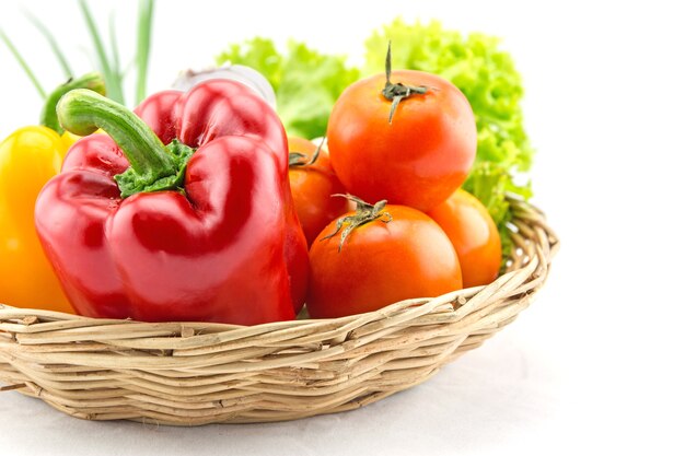 Organic vegetables in the wicker basket on white background