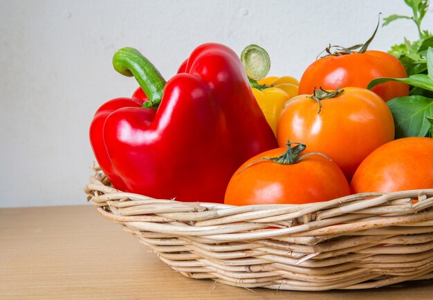 Organic vegetables in the wicker basket on wooden background