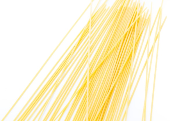 Organic yellow spaghetti pasta on a white background.