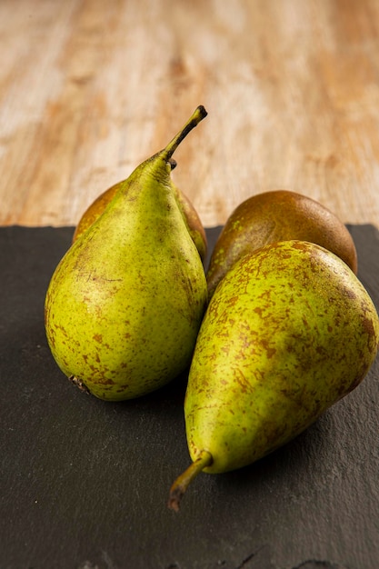 Organically grown pears on black slate and old wood