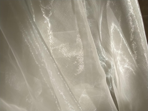 Organza in white and beige or champagne color closeup Lightweight sheer tulle curtains under side lighting