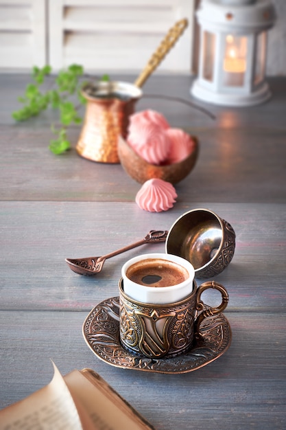 Oriental coffee cooked in traditional Turkish copper coffee pot and  served in a matching cup