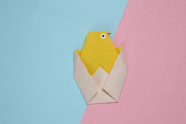 Origami chicken on pink blue background