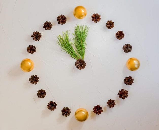 Original new year clock made of balls and cones pine branches instead of arrows flat lay copy spa