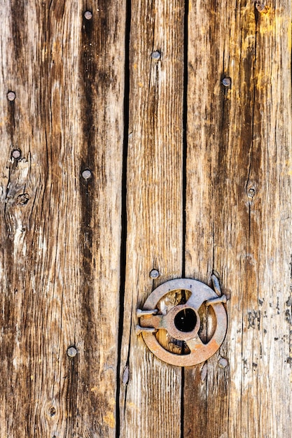 Original vintage background from wooden boards with nails and an iron disk.