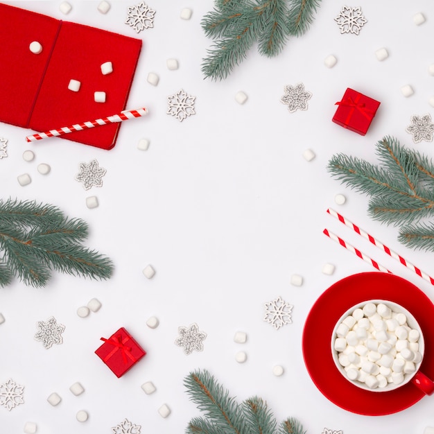 Ornaments, fir branches, cup of hot chocolate with marshmallow and red gift boxes 