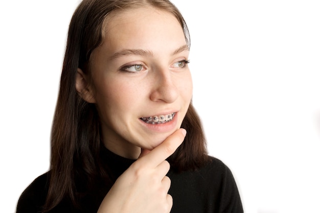 Orthodontic treatment. Dental care concept. Smiling teenage girl with braces. Metal braces close-up on the teeth. High quality photo