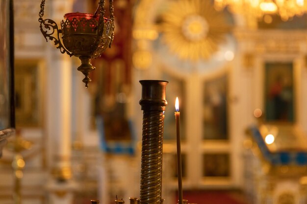 Orthodox church christianity festive interior decoration with burning candles and icon in traditiona...