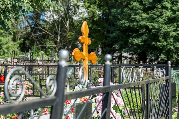 Orthodox wooden cross on a grave in a Christian cemetery in summer vegetation Memory and sorrow