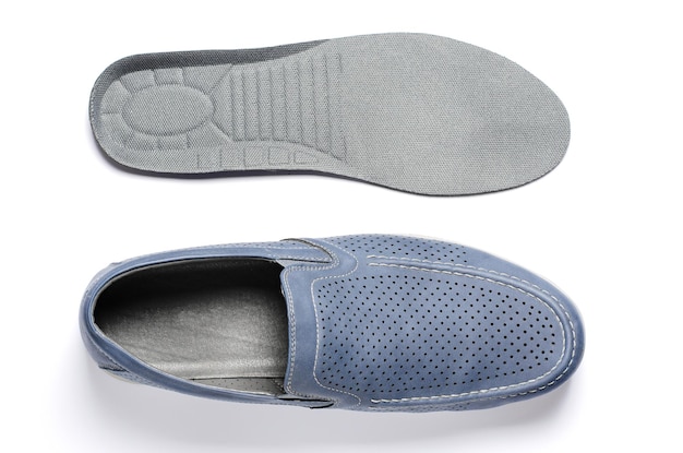 Orthopedic insoles and men's shoes White background The concept of prevention of diseases of the feet and flat feet Comfort of wearing shoes