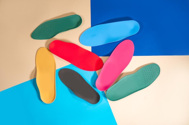 Orthopedic insoles for shoes on a colour background Foot care