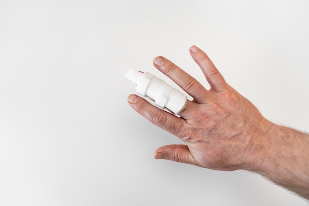 Orthosis for fixing the finger on hand on a white background. langet to heal the phalanxes of the fingers, due to injuries. orthopedic accessories. pharmacy and medical equipment.