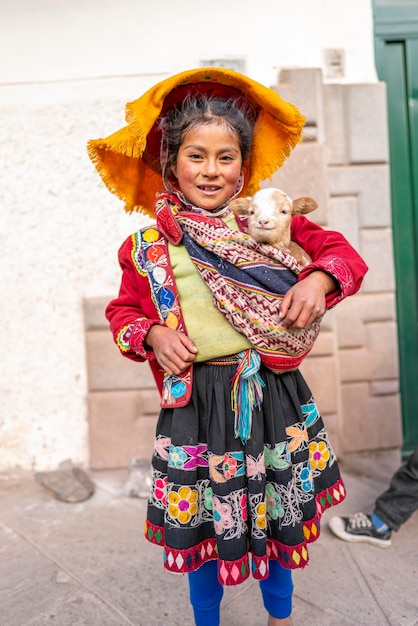 ortrait of a Peruvian girl dressed in a colorful handmade traditional Cusquenian costume. Andean gir