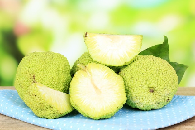 Osage Orange fruits Maclura pomifera in basket on wooden table on nature background