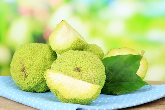 Osage Orange fruits Maclura pomifera in basket on wooden table on nature background