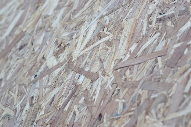 OSB boards made of brown wood chips sanded into a wooden background Top view of OSB wood veneer background surface