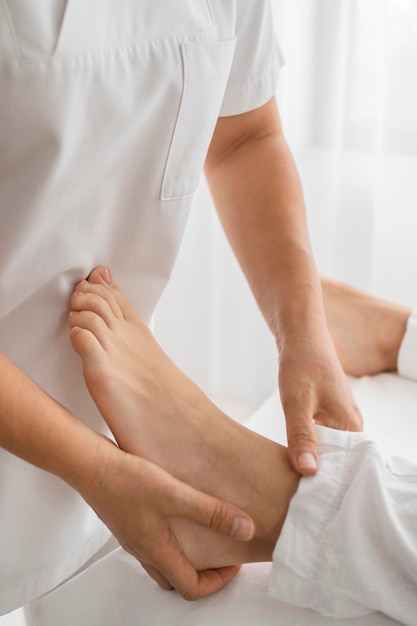 Osteopathist treating a patient on his feet