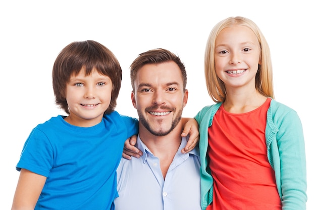 Our father is the best! Happy father carrying two cheerful children and smiling while standing against white background