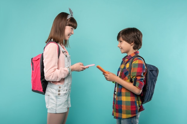 Our friendship. Inspired adorable schoolchildren smiling and holding their tablets