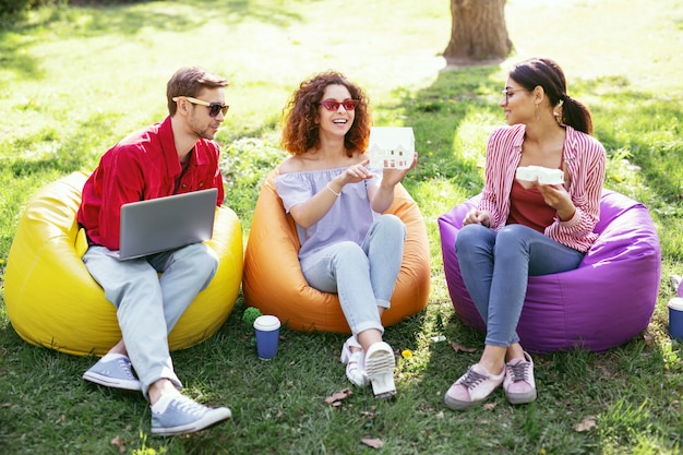 Our future project. Cheerful ambitious colleagues sitting in the open air and working on the project