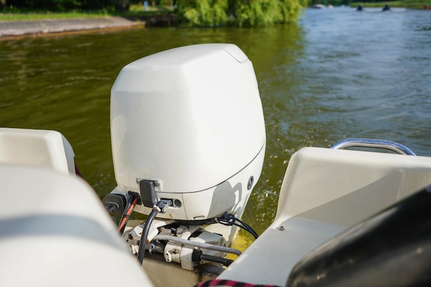 Outboard engine Close up of white outboard motor on the lake Boat swimming on the river