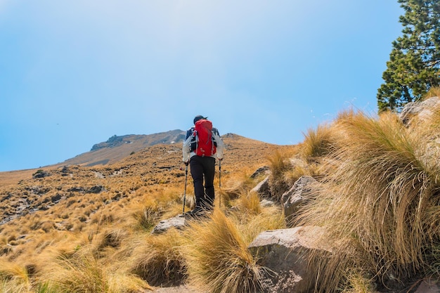 Outdoor adventure Man trekking to the top of the mountain Inspiration and personal achievement